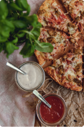Pizza Salvatore podana z sosem pomidorowym oraz czosnkowym i świeżą bazylią